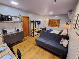 a living room with a couch and a kitchen at Casa VNE 01 in Araranguá