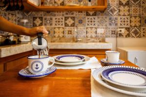 a person is pouring coffee into a cup on a table at Vila Maria Pousada in Jericoacoara +34 photos