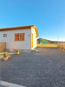 a house with a gravel driveway in front of it at Casa VNE 01 in Araranguá