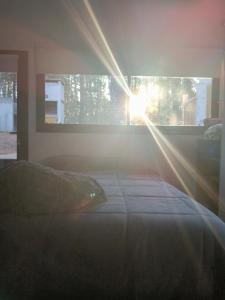 a bedroom with a bed with the sun shining through the window at Big Sur in Mar Azul