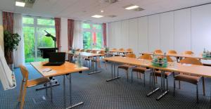 ein Klassenzimmer mit Tischen, Stühlen und einem Laptop in der Unterkunft Quick Hotel Dresden 24H Self Check-in in Dresden