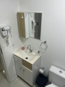 a bathroom with a sink and a mirror and a toilet at Casa completa bem equipada ótima localização in Joinville +14 photos