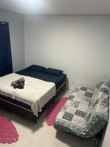 a bedroom with two beds and a stuffed animal on the floor at Casa completa bem equipada ótima localização in Joinville