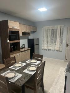 a kitchen with a table and chairs and a kitchen with a table and a table at Casa completa bem equipada ótima localização in Joinville