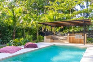 a swimming pool in a backyard with a pergola at Private Jungle House No1Calalu with AC, Pool & EV in Talamanca