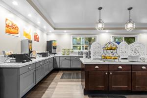 a large kitchen with gray cabinets and a counter top at Quality Inn & Suites Santa Maria in Santa Maria