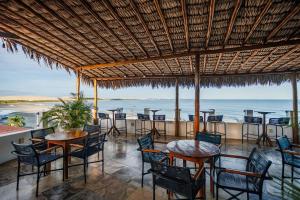a restaurant with tables and chairs and the ocean at Vila Maria Pousada in Jericoacoara