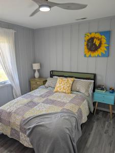 a bedroom with a bed and a sunflower on the wall at Otterspace at the beach in Shady Side