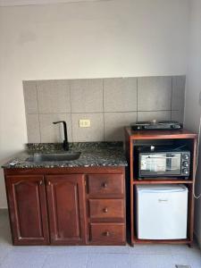 a kitchen with a sink and a microwave at 9 De Julio in Charata