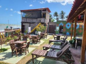 an outdoor restaurant with tables and chairs and the beach at Ocean View Riohacha in Ríohacha