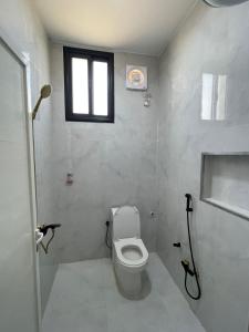 a bathroom with a toilet and a window at سويتات توت in Al Mikhlaf