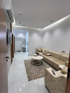 a living room with a couch and a table at سويتات توت in Al Mikhlaf
