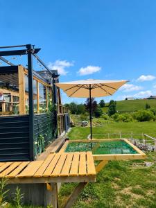 a wooden deck with an umbrella next to a pool at MonteRosso in Mărişel