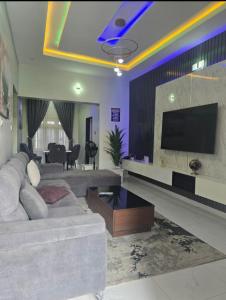 a living room with a couch and a flat screen tv at O2 Continental Suites in Kubwa