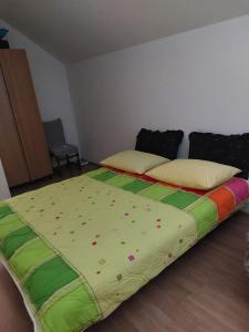 a bedroom with a bed with a colorful blanket on it at Villa Valinor in Slatina Varoš +10 photos