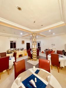 a restaurant with tables and chairs and a fireplace at Lexworld Hotels in Aba