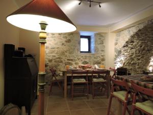 a dining room with a table and a lamp at Gartagani Guest House in Stemnitsa