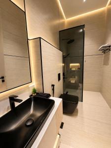 a bathroom with a black sink and a toilet at مساكن لينا الفندقية in Abha
