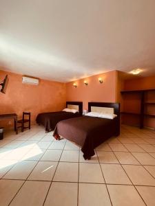 a bedroom with two beds in a room at Hotel Camino Surreal Xilitla in Xilitla