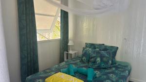 a bedroom with a blue bed with a window at LE FARE BLEU DUO 2 chambres climatisées avec 1 salle de bain - bord de lagon à Tiputa Rangiroa - vélos gratuits et snorkeling in Rangiroa