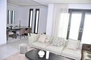 a living room with a white couch and a table at F3 ngor virage in Dakar