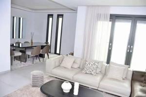 a living room with a white couch and a table at F3 ngor virage in Dakar