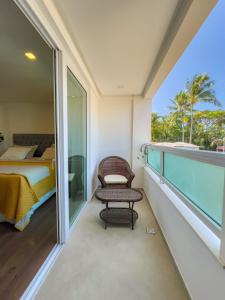 a room with a balcony with a bed and a chair at Pousada Pénareia in Morro de São Paulo