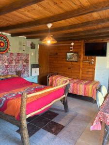 a bedroom with two beds and a flat screen tv at Rancho Por Fin in Barreal