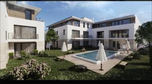 an apartment building with a swimming pool and two umbrellas at Luxus Lakópark in Gárdony