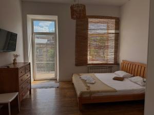 a bedroom with a bed and a television and a window at Belle Art Hotel in Odesa