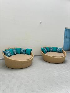 two couches with blue pillows sitting in a room at Hotel Jemara in San Gil