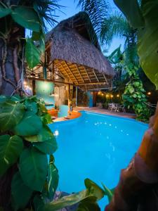 a villa with a swimming pool and a thatched building at Hotel Camino Surreal Xilitla in Xilitla