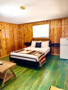 a bedroom with a bed in a room with wooden walls at Bellamy's Ski Haus in Red River