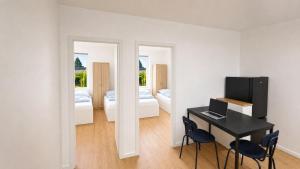 a room with a desk and two chairs and a bedroom at CityNest Apartment Mülheim in Mülheim an der Ruhr +7 photos