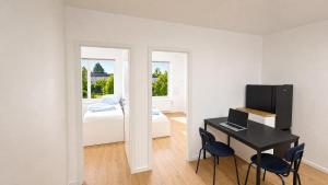 a room with a desk and a bedroom with a bed at CityNest Apartment Mülheim in Mülheim an der Ruhr