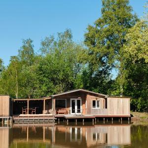 ein Haus auf einem Steg an einem Gewässer in der Unterkunft Chalet WILD in Geel