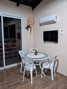 a dining room with a table and chairs and a tv at Pousada Siriemas in Cambará