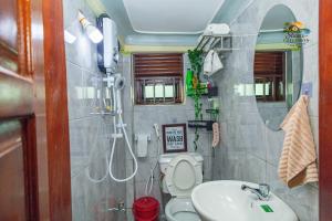 a bathroom with a shower and a toilet and a sink at Shan in Jinja
