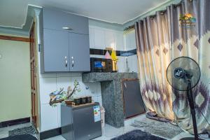 a kitchen with blue cabinets and a refrigerator at Shan in Jinja