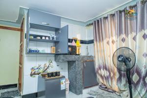 a kitchen with a refrigerator and a shower curtain at Shan in Jinja +8 photos