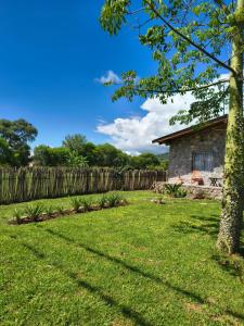 a yard with a fence and a house at Cabañas 2TIERRAS in Chicoana