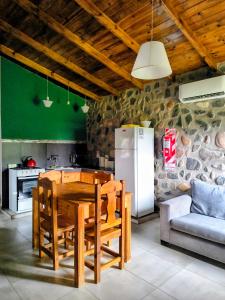 a kitchen with a wooden table and a refrigerator at Cabañas 2TIERRAS in Chicoana