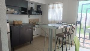 a kitchen with a counter and a island with bar stools at Casa Morelia ideal, rest or work in San Carlos