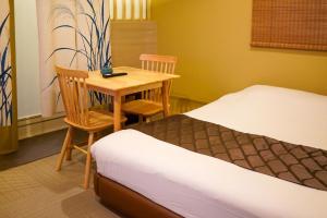 a bedroom with a bed and a table and chairs at HOTEL 壮-soh-shibuya in Tokyo +33 photos