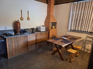 a kitchen with a wooden table and a kitchen with a stove at Pousada Pindobas in Venda Nova do Imigrante