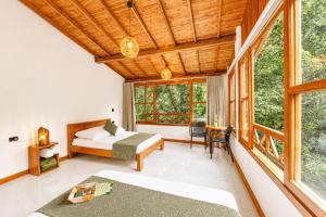 a bedroom with a bed and a desk and windows at Hotel Termales Espiritu Santo in Nariño