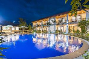a large pool in front of a building at night at Sunset Mountain View Resort in Vang Vieng