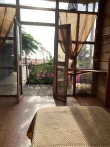 a room with a bed and a glass door at Negritos Beach House in Negritos