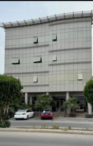 a building with cars parked in front of it at شقق فندقيه in Buraydah
