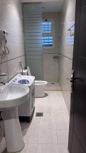 a bathroom with a sink and a toilet and a shower at شقق فندقيه in Buraydah